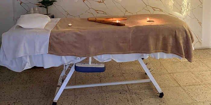Cañas de bambú y velas sobre la camilla, listas para una sesión corporal